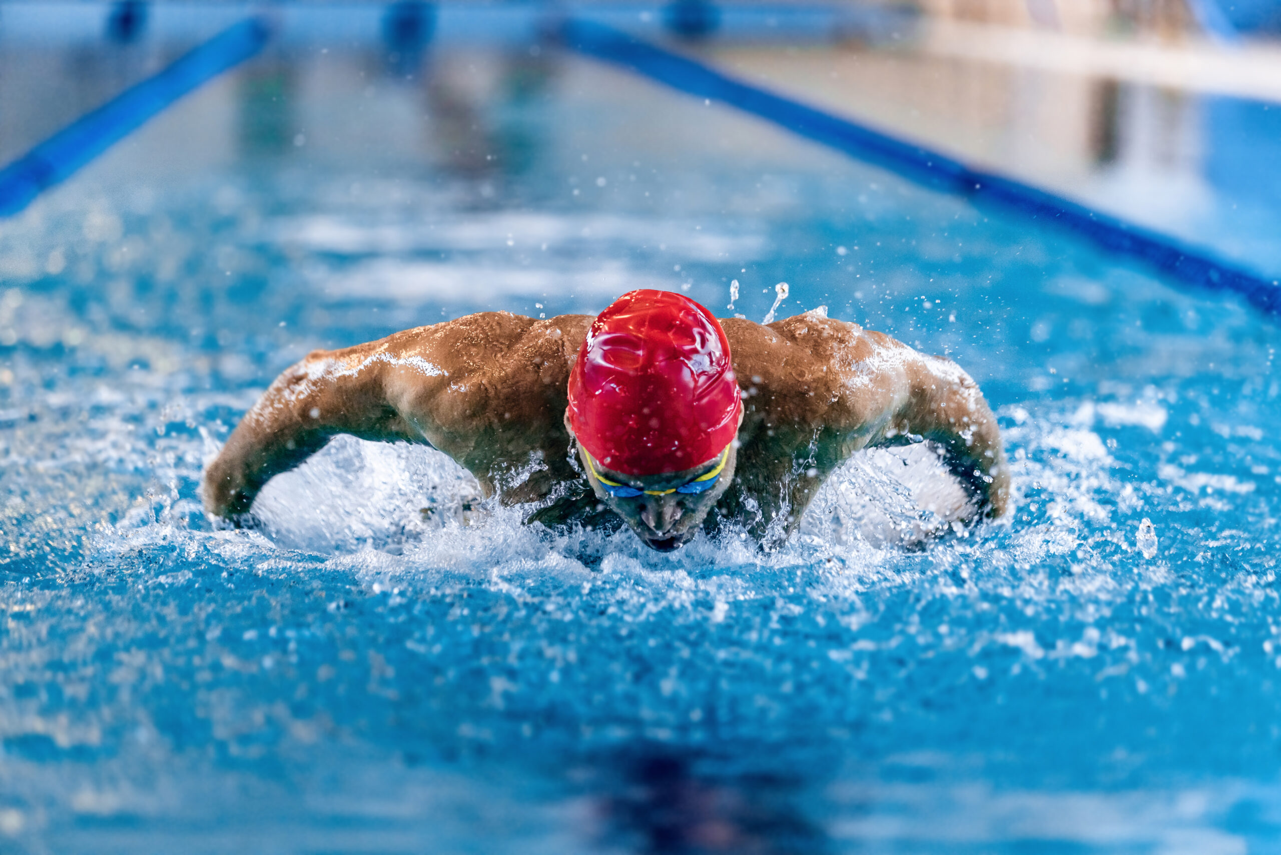 Competitive swimmer in red cap and goggles